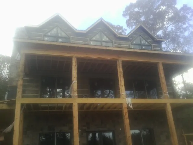 Dormers and porch framing on a large log home under construction — Roof Coating work by our crew in Hornsby